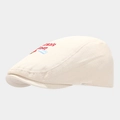 Detail of beige cotton flat cap with red Jean's Diner embroidery and blue graphic icon - One Size (56-60cm) / White