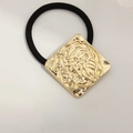 Black elastic hair tie featuring a square gold-tone metal plate with lava texture - Square Flower Pattern Gold