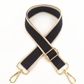 Detail of adjustable woven strap with maze pattern and golden metal swivel snap hooks - Black