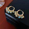 Vintage style golden hoop earrings with turquoise round pendants on a blue box - Gold Hoop Turquoise Tassel Earrings