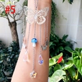 Detail of butterfly suncatcher with colorful crystal prisms and mushroom charm hanging - Silver Moon Blue Mushroom