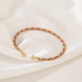 Detail of bohemian handmade colorful woven bracelet with golden metal end caps - Multicolor