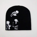 Black knit beanie featuring white pixelated figure pattern on a clean white background - Black