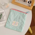 Close-up of mint green crinkled fabric storage bag with pink zipper and rainbow text label - Mint Green (Vertical)