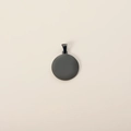 Close-up of a minimalist round black stainless steel pet ID tag with a polished finish - Black