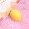 Close-up of yellow resin lemon charm with metal loop on pink mesh background - with Hook / Lemon