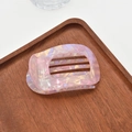 Close-up of pink acetate hair claw with iridescent pearlescent finish in a wooden tray - Pearlescent Claw / Pink Mermaid