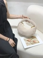 Detailed close-up of woven beige crescent bag texture with a sleek golden zipper - Off White