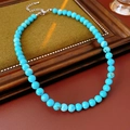Dettaglio della collana di perline turchesi azzurre su un espositore in legno vintage - Diametro perla 8mm