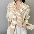 Dettaglio ravvicinato dello scialle in maglia a righe beige e bianco per un look chic - Cachi