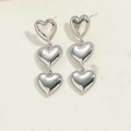 Detail of silver triple heart drop earrings with high-polish finish and beaded edges - Platinum Plated Triple Heart