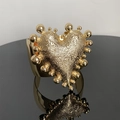 Detail van vintage gouden manchetarmband met groot gehamerd hart en getextureerde afwerking - B18 Armband / Goud