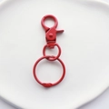 Close-up of bright red lacquered metal dog head lobster clasp with ring for bag accessories - Red