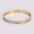 Detalle de brazalete dorado de acero con incrustaciones de circonitas rectangulares - Dorado