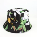 Close-up of black bucket hat featuring white magnolia floral and bird print patterns - Dark Green
