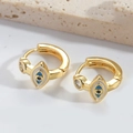 Detail of gold evil eye hoop earring with blue enamel and small zircon on stone base - White
