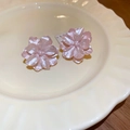Detailansicht der rosa Kamelien-Ohrstecker mit Perlmuttglanz auf einer Keramikplatte - Rosa