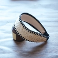 Detailed view of woven raffia headband with black decorative stitching and herringbone texture - Beige with Black Stitching