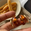 Macro shot of gold C-shaped earrings with amber resin ring detail on a finger - 18# Silver Needle Gold Amber C-Shape