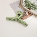 Macro shot of large matte avocado green shark hair claw clip with twisted cross design - Cross / Bean Green