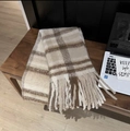 Detail shot of the thick tassels and plaid cashmere-like fabric of the warm winter scarf - Baba Plaid Beige
