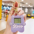 Vue détaillée du porte-clés console de jeu ours violet avec anneau doré et boutons - Violet
