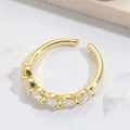 Adjustable gold ring featuring five inlaid clear zircon stones on a white textured surface - Oval White Zircon