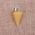 Macro detail of faceted golden crystal cone pendant with metal clasp on rustic linen fabric - Topaz