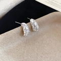 Macro detail of silver screw-thread earrings with sparkling crystal pavé inlay - Silver