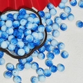 Detailed view of blue and white porcelain style beads in a white floral shaped dish - Imitation Porcelain Round Bead (J174) / 10mm