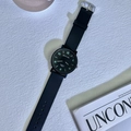 Reloj de cuarzo minimalista con correa negra y números verdes luminosos sobre fondo blanco - Tamaño Grande - Esfera Negra Luminosa Semi-Numérica