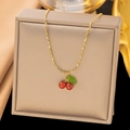 Elegant gold cherry pendant necklace with red carnelian stones on a silk display - AH218 Cherry Pendant Gold