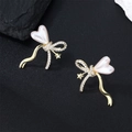 Elegant gold bow earrings with heart pearl and star charms on black rock background - Bow Star Style (E01240G)