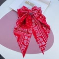 Red paisley print vintage bow hair clip with ribbons on a clean pastel background - Bright Red Cashew Print Ribbon