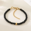 Détail macro de perles de lave noire avec accents dorés et chaîne à breloque cœur - Style Pierre de Lave Noire Doré (KB207125-Z)