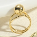 Macro shot of minimalist gold double ring with a large polished spherical metal bead detail - Double Ring Single Large Bead