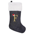 Detail of grey velvet Christmas stocking with white faux fur cuff and golden embroidered letter F - Letter F