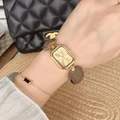 Elegant gold square watch with grey leather strap shown on wrist with bracelet - Style 22069