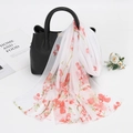 White chiffon scarf with red floral print tied on a black handbag for sun protection - White (Artistic Red Floral)