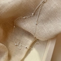 Gros plan d'un collier en argent S925 avec breloques cœur sur tissu beige - Argent 925 / Argent