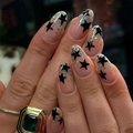 Unghie finte a mandorla corte con stelle nere e glitter olografici su base nude - Tipo di Colla