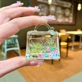 Dettaglio del portachiavi a borsa in acrilico con fiori colorati e perline fluide - Giallo