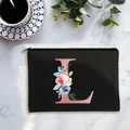 Black canvas cosmetic bag with pink floral letter L on white marble background - Letter L