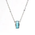 Detailansicht einer silbernen Halskette mit zylindrischem Anhänger und blauen Steinen - Silber Mit Blauem Zirkonia