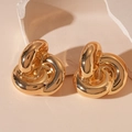 Makroaufnahme goldener Knotohrringe mit polierter Metalloberfläche auf weichem Grund - Keltischer Knoten-Stil / Gold
