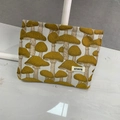 Portable beige makeup bag with yellow mushroom patterns and ATRYG brand label - Yellow