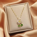 Detailed close-up of a daisy pendant necklace with yellow and white zircon on a gold chain - Gold + Lip Chain - Dark Green Daisy