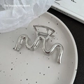 Large silver metal shark hair claw clip in a minimalist wavy design on ceramic tray - 27# Small M Silver