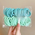 Detail of high-elasticity hair ties in sky blue and mint green within a clear bag - Green Series 50Pcs