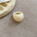 Minimalist cream resin ring on a textured felt surface with aesthetic ceramic accents - Off White